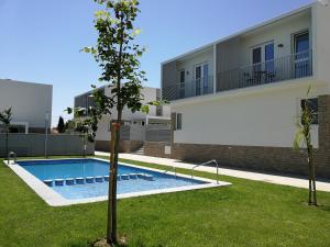 a villa with a swimming pool in front of a building at Preciosa casa en Alcossebre in Alcossebre