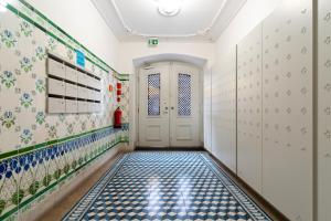 een hal met blauwe en witte tegelvloeren en een deur bij Baixa Charming Apartment in Lissabon