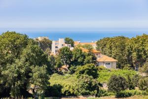 ein Haus auf einem Hügel mit Bäumen und dem Meer in der Unterkunft Foz Premium Retreat in Porto