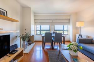 a living room with a table and a blue couch at Foz Premium Retreat in Porto