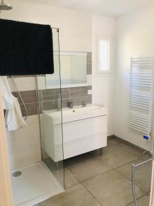 y baño con lavabo blanco y espejo. en Gîte Aléria Ardèche, en Saint-Martin-dʼArdèche