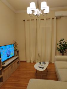 a living room with a couch and a tv and a table at Lovely Eleana Apartment in Corfu in Corfu Town