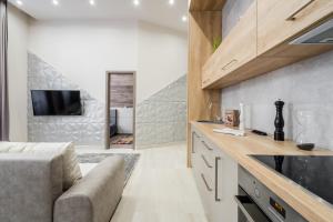 una cucina e un soggiorno con un divano e una TV di Central comfort suite for 6 by Oktogon a Budapest