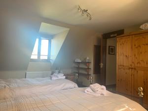 A bed or beds in a room at Burnt Mill Cottage