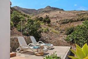 a group of chairs sitting on a porch with a mountain at Casa Buenavista in Hoya de Pineda