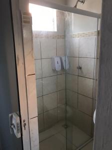 um chuveiro com uma porta de vidro na casa de banho em flat Luiz Carlos Mouzinho em Teresina