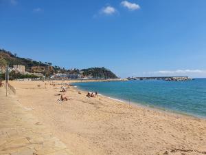 a group of people laying on a beach at Habitación delante de la playa Blanes in Blanes