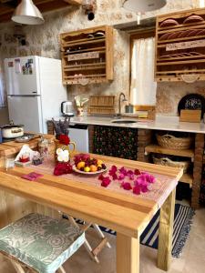 a kitchen with a wooden table with a bowl of fruit at Ambar Evleri in Kalkan