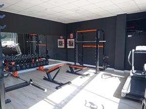 un gimnasio con dos estantes de pesas en Apartamentos Hi Apartaments Santander 3000, en Maliaño
