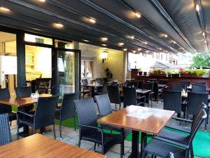 a restaurant with wooden tables and chairs and tablesearcher at Hotel Restaurant Toscana in Bad Orb