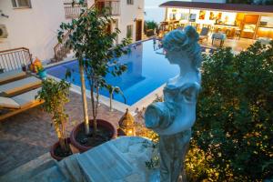 a statue of a woman standing next to a pool at Sunset Villa Hotel in Kaş