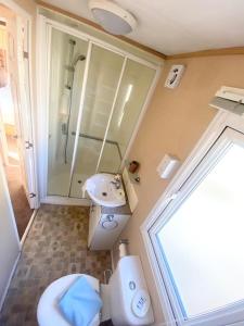ein Badezimmer mit Toilette, Waschbecken und Dusche in der Unterkunft Luxury 2 Bedroom 2 bathroom Caravan-small sofa 1 pers in Saint Osyth