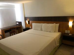 a bedroom with a large bed in a hotel room at Suíte NATAL PLAZA in Natal