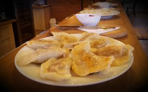 a plate of dumplings on a wooden table at Gościniec Piast Hotel i Camping in Brzeźno