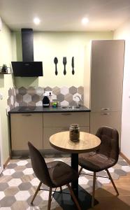 a kitchen with a table and two chairs and a counter at Vite, au bien-être in Vitteaux +6 photos