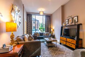 een woonkamer met een bank en een tv bij Middlethorpe Manor - No1 Relax and Unwind in York