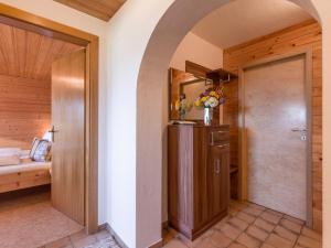 einen Flur mit einer Tür zu einem Zimmer mit einem Bett in der Unterkunft Appartement Salvenblick in Hopfgarten im Brixental