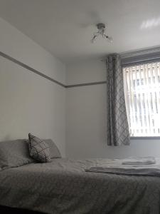 Schlafzimmer mit einem Bett und einem Fenster in der Unterkunft Cosy Room in Galashiels in Galashiels