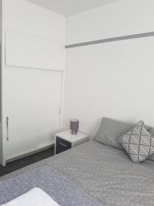 a white bedroom with a bed and a night stand at Cosy Room in Galashiels in Galashiels