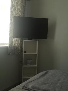 Schlafzimmer mit einem Bett und einem Flachbild-TV in der Unterkunft Cosy Room in Galashiels in Galashiels
