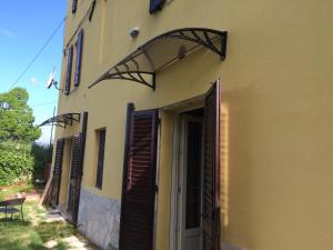 um edifício com uma porta aberta com um banco ao lado em Casavacanze Ciaspole E Uva em Fiastra
