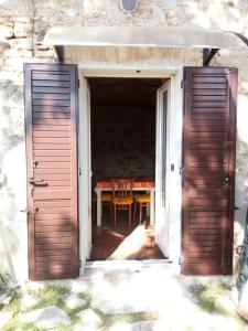 an open door leading into a patio with a table at Casavacanze Ciaspole E Uva in Fiastra