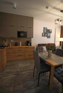 uma sala de estar com uma mesa e uma cozinha em Shellter Apartament Nadmorski em Rogowo
