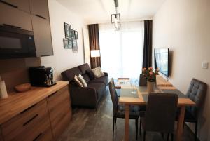 sala de estar con sofá y mesa de comedor en Shellter Apartament Nadmorski en Rogowo