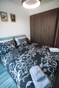 um quarto com uma cama com um cobertor preto e branco em Shellter Apartament Nadmorski em Rogowo