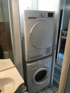 Un baño con lavadora y lavabo. en Bienvenue chez nous, en Arc 2000