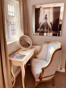 - un dressing avec une chaise et un miroir dans l'établissement Nuthurst Grange Country House Hotel & Restaurant, à Solihull