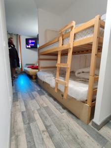 um quarto com 2 beliches e piso em madeira em Bienvenue chez nous em Arc 2000