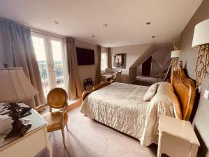 um quarto com uma cama e uma mesa com um candeeiro em Nuthurst Grange Country House Hotel & Restaurant em Solihull