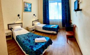 a hotel room with two beds and a window at Hotel Nord in Voronezh