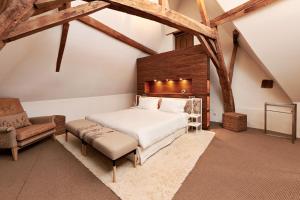 una camera con un grande letto e una sedia di Indrani Lodge a Loupoigne