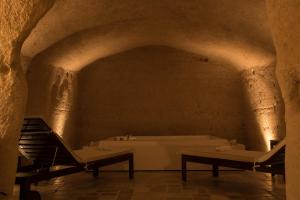 une salle de bains avec baignoire dans une grotte dans l'établissement LA DIMORA DELLE 3 ZIE, à Matera