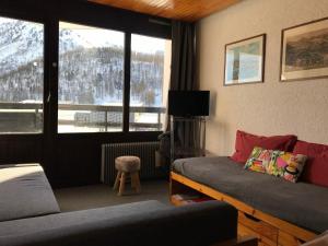 um quarto com uma cama, um sofá e uma janela em Appartement Montgenèvre, 2 pièces, 6 personnes - FR-1-445-98 em Montgenèvre