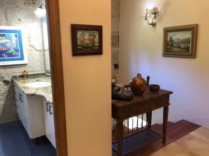 Un baño con lavabo y una mesa con espejo. en Villa Casa de Campo Los Carballos, en Tomiño 56 fotos más