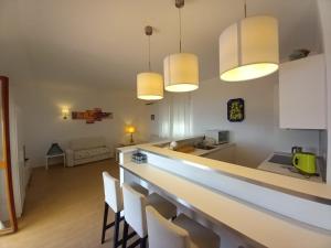 a kitchen with a bar with chairs and lights at WHITE LOTUS Apartment in Taormina