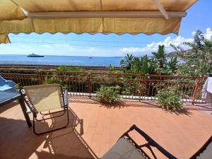 a patio with chairs and a view of the ocean at WHITE LOTUS Apartment in Taormina