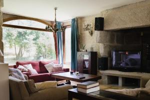 uma sala de estar com um sofá e uma televisão em Villa Casa de Campo Los Carballos em Tomiño