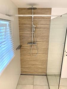 La salle de bains est pourvue d'une douche avec un mur en bois. dans l'établissement Haigis Lodge, à Annaberg-Lungötz