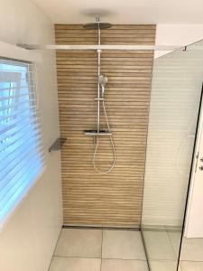 a shower with a wooden wall in a bathroom at Haigis Lodge in Annaberg im Lammertal