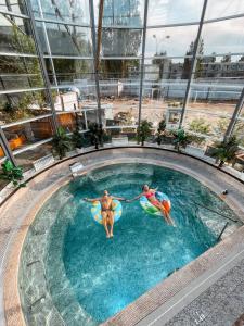 dos personas en una piscina sobre inflables en Dolphin Planet Hotel & SPA, en Yaroslavl