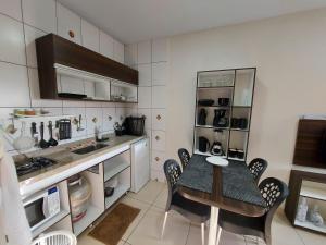 a kitchen with a table and chairs in a room at Flats Atitude Maragogi centro in Maragogi