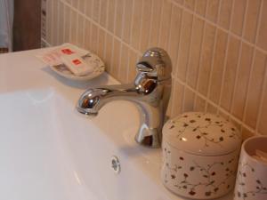 lavabo con grifo y taza en Casa Navarrete, en El Cuervo