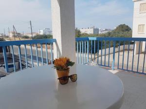 a table with glasses and a plant on a balcony at Cozy holyday apartament in Paralimni