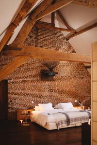 een slaapkamer met een bakstenen muur en een bed bij Indrani Lodge in Loupoigne