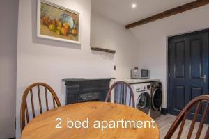 een eetkamer met een tafel en een wasmachine bij Market Square Grade II Listed Apartment in Macclesfield