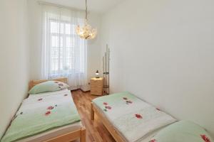 two twin beds in a bedroom with a chandelier at Mediterraneo-Rheinufer-Vallendar in Vallendar